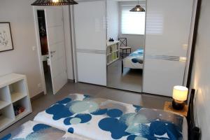 Schlafzimmer mit einem Bett mit einer blauen und weißen Bettdecke in der Unterkunft A l'Ancien Moulin in Lampertheim