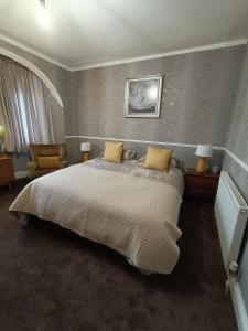 um quarto com uma cama grande e almofadas amarelas em The Golden Sands B&B em Blackpool