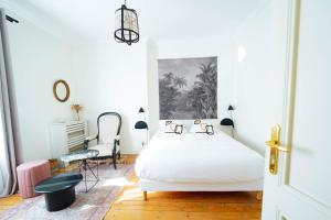 a white bedroom with a bed and a desk at B&B La Maison Galiène in Bordeaux