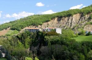 a mountain with houses on top of it at Locanda delle grotte di Onferno in Gemmano