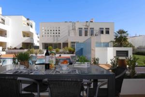a table on a balcony with a bottle of wine at Apartamento Canada Formosa Cabanas Beach by Your Home Algarve in Cabanas de Tavira