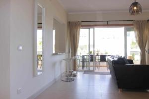 a living room with a couch and a view of a patio at Apartamento Canada Formosa Cabanas Beach by Your Home Algarve in Cabanas de Tavira