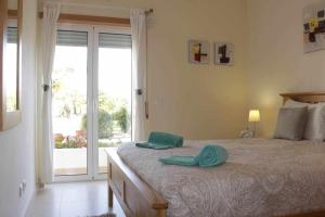 a bedroom with a bed with a pair of towels on it at Apartamento Canada Formosa Cabanas Beach by Your Home Algarve in Cabanas de Tavira