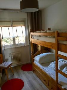 een slaapkamer met 2 stapelbedden en een rood tapijt bij Choucas A16 in Crans-Montana