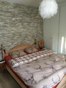een slaapkamer met een bed en een bakstenen muur bij Choucas A16 in Crans-Montana