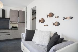 ein Wohnzimmer mit Sofa und etwas Fisch an der Wand in der Unterkunft 021 - Casa Ponente con Terrazzo - CENTRO città, Carruggio e Mare BAIA DEL SILENZIO a 500 m in Sestri Levante