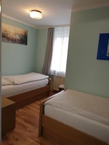 a room with two beds and a window at Der Prinsenhof in Porta Westfalica