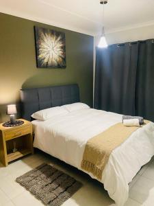 a bedroom with a large white bed and a table at The Blyde Crystal lagoon, Pretoria (2 beds) in Pretoria