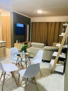 a living room with a table and chairs and a couch at The Blyde Crystal lagoon, Pretoria (2 beds) in Pretoria +15 photos