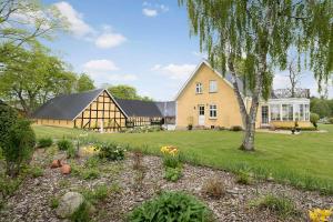 a home with a large barn and a yard with flowers at Brigsted B&B in Horsens