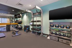 Tru By Hilton Comstock Park Grand Rapids, MI في Comstock Park: غرفة لياقة بدنية مع صالة رياضية مع تلفزيون بشاشة مسطحة