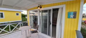 a yellow house with a balcony with a table and a door at Harrys Cottage 4 in Dulcina