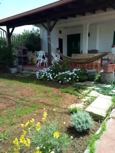 a yard with a hammock and flowers in front of a house at Villa Itaca in Sant'Isidoro