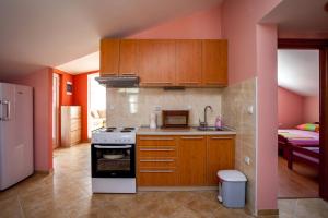 a kitchen with wooden cabinets and a stove at Apartment Kandic in Tivat