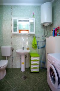 a bathroom with a sink toilet and a washing machine at Apartment Kandic in Tivat