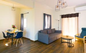 een woonkamer met een bank en een tafel en stoelen bij Elounda Harmony Sea front apartment in Elounda