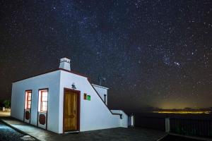 una piccola cappella bianca sotto un cielo stellato di Neólida a Puntallana