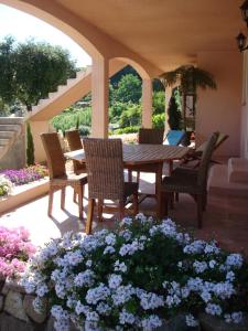 a patio with a table and chairs and flowers at Appartement Appietto in Appietto