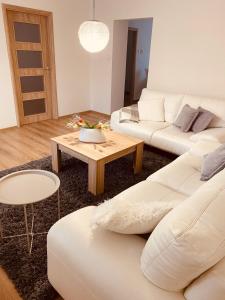 a living room with two white couches and a table at Trio Apartments in Ostrava