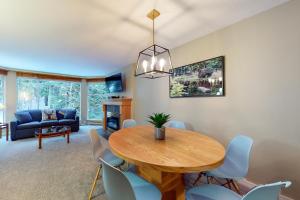 a living room with a dining room table and chairs at Woodrun #418 in Whistler
