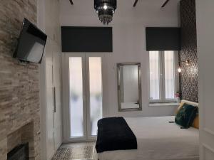 1 dormitorio con 1 cama con chimenea y TV en LA SUITE DEL CONDE LUXURY SUITES, en Sevilla