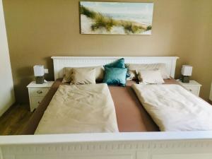een slaapkamer met 2 bedden met kussens erop bij Maison Bibéc in Hofgeismar
