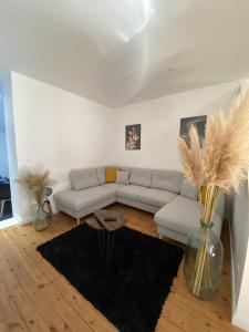 uma sala de estar com um sofá e um vaso com penas em Agreable et vaste maison Angouleme centre ville em Angoulême