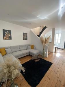 a living room with a couch and a table at Agreable et vaste maison Angouleme centre ville in Angoulême