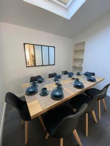 uma sala de jantar com uma mesa com cadeiras e um espelho em Agreable et vaste maison Angouleme centre ville em Angoulême