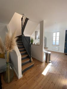 - un escalier dans un salon avec un vase à l'étage dans l'établissement Agreable et vaste maison Angouleme centre ville, à Angoulême