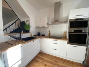 a kitchen with white cabinets and a stove top oven at Agreable et vaste maison Angouleme centre ville in Angoulême