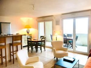 cocina y sala de estar con mesa y sillas en Grand Bleu, en Sète