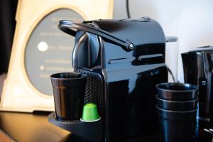 una cafetera y dos tazas en un escritorio en Cocoon-Chambre d'Hôtes, en Namur