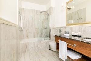 ein Badezimmer mit Badewanne, Toilette und Waschbecken in der Unterkunft Hotel Le Premier in Zagreb + 100 Fotos