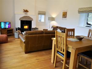 a living room with a couch and a table and a fireplace at The Fish House in Kirkcudbright