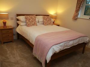 Un dormitorio con una cama grande con almohadas. en The Fish House, en Kirkcudbright