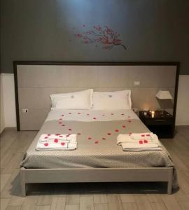 ein Bett mit roten Blumen darauf in einem Schlafzimmer in der Unterkunft lapietra_hotelescapes in San Gennaro Vesuviano