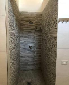 un bagno con doccia con parete in pietra di lapietra_hotelescapes a San Gennaro Vesuviano