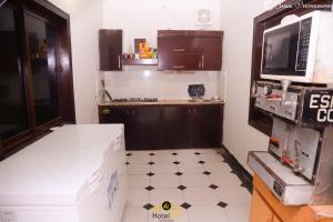 eine Küche mit einer Box auf dem Boden und einer Mikrowelle in der Unterkunft Hotel Inn Hyderabad in Hyderabad