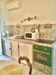 een keuken met een fornuis en een magnetron op een aanrecht bij Coquet T2 au coeur du village in Sartène