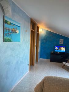 ein Wohnzimmer mit einer blauen Wand und einem TV in der Unterkunft Casa vacanze costa dei Trabocchi in Fossacesia