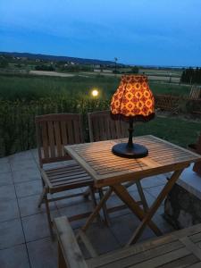 lampa na drewnianym stole obok dwóch krzeseł w obiekcie Emese Apartman Cserszegtomaj w mieście Cserszegtomaj