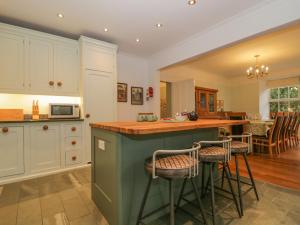a kitchen with a green island with bar stools at The Old Vicarage in Thirlmere