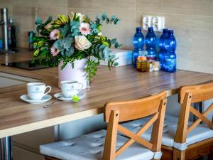 a table with two chairs and a vase with flowers at Słoneczna 10a w Jarosławcu Apartamenty nad morzem in Jarosławiec
