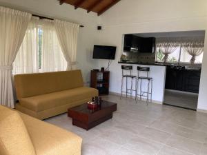 a living room with a couch and a kitchen at Hotel Palmera Real in Bucaramanga