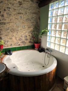 a large bath tub in a bathroom with a window at Casa ideal para grupos, Rustic Oh in Xert