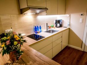 a kitchen with a sink and a vase of flowers at Słoneczna 10a w Jarosławcu Apartamenty nad morzem in Jarosławiec +105 photos