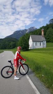 a man standing next to a bike on a road at Ferienwohnungen Wagenstaller in Söllhuben