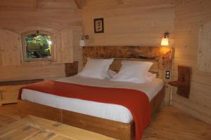 Кровать или кровати в номере Les Cabanes Dans Les Bois Logis Hôtel