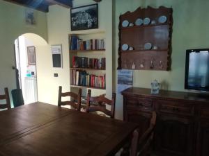 a dining room with a wooden table and a tv at Il casale di Pino e Rita in Subiaco